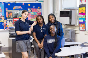 4 female students posed together in classroom