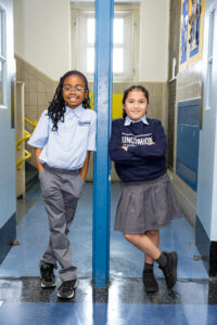 two young female students posed in doorway