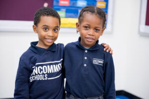 image of two young students hugging shoulders