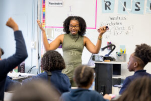 picture of female teacher excitedly smiling while interacting with the classroom